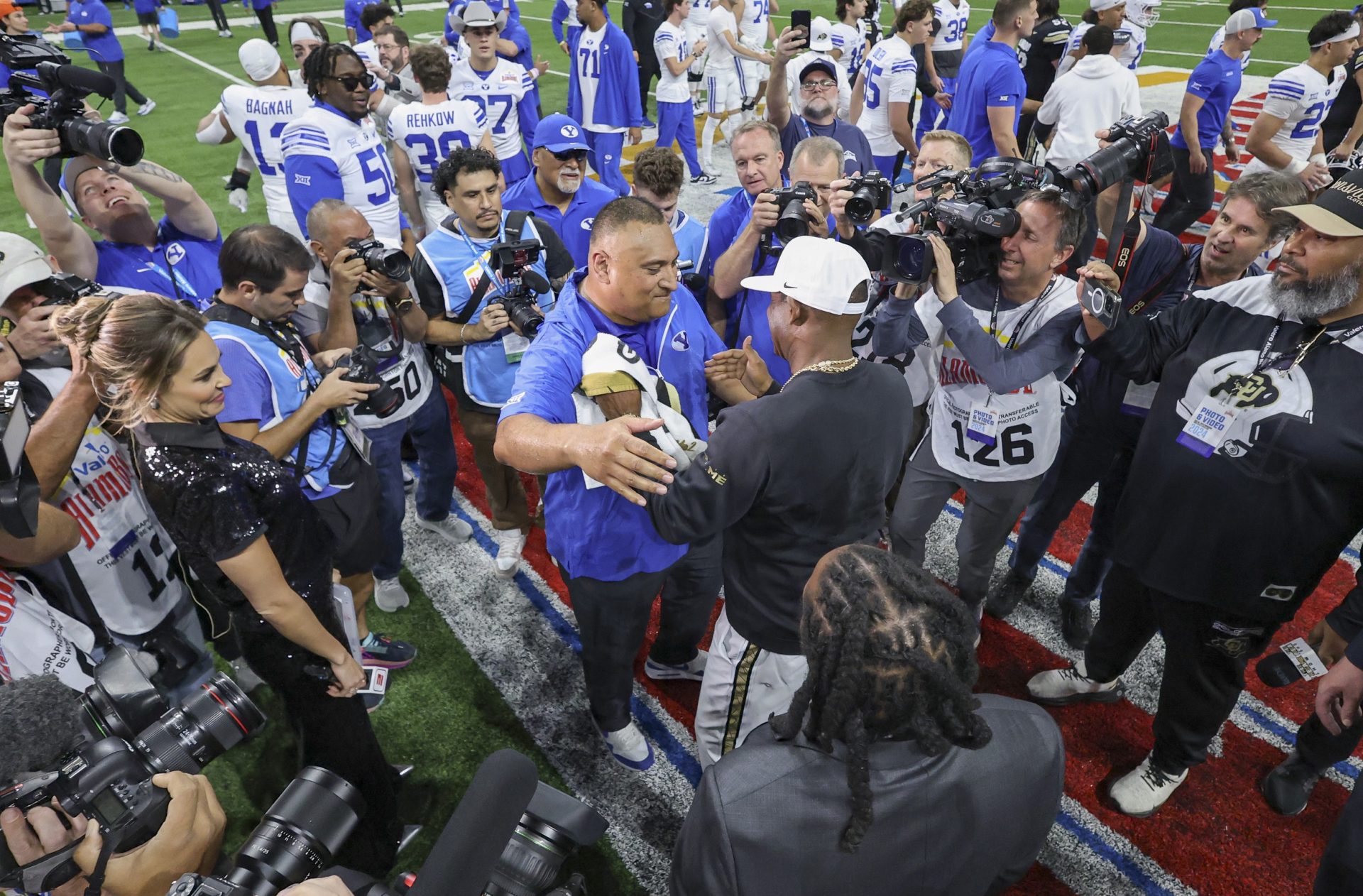 Brigham Young Cougars head coach Kalani Sitake and Colorado Buffaloes head coach Deion Sanders greet on the field after the game at Alamodome.