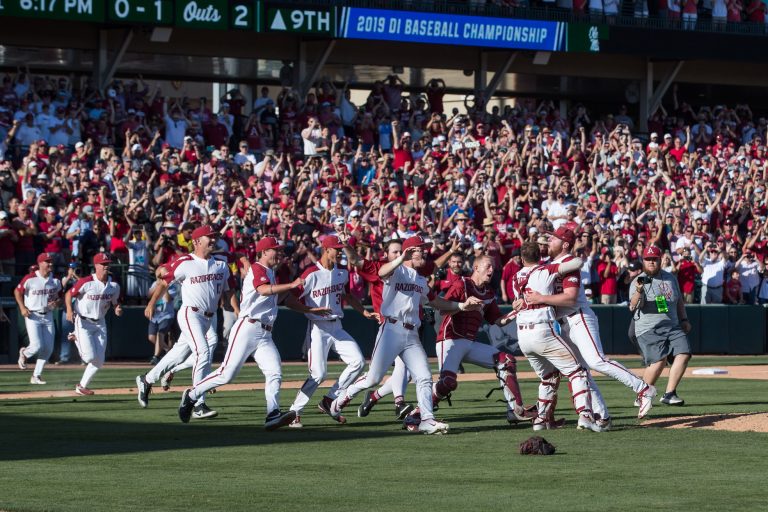Arkansas Razorbacks players rush onto the field after defeating the Mississippi Rebels at Baum-Walker Stadium.