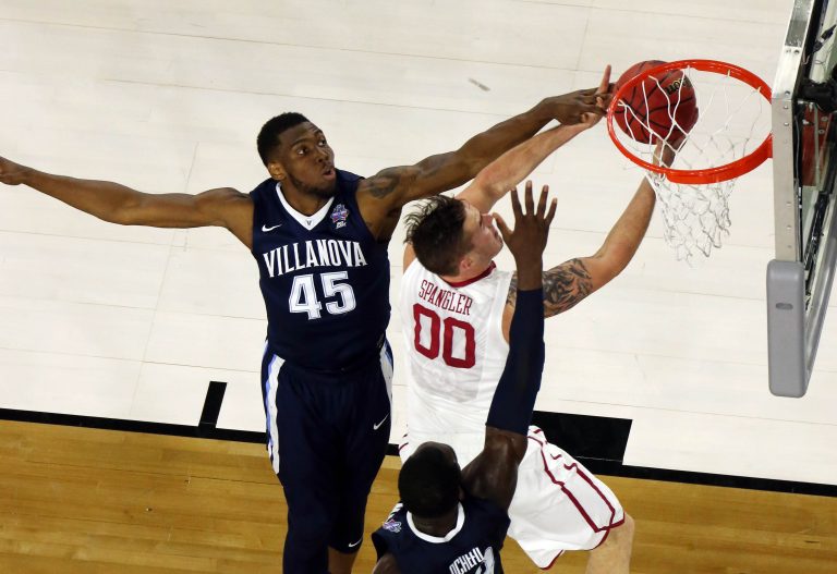 Oklahoma Sooners forward Ryan Spangler (00) lays the ball up defended by Villanova Wildcats forward Darryl Reynolds (45) and Daniel Ochefu (23) during the second half in the 2016 NCAA Men's Division I Championship semi-final game at NRG Stadium.