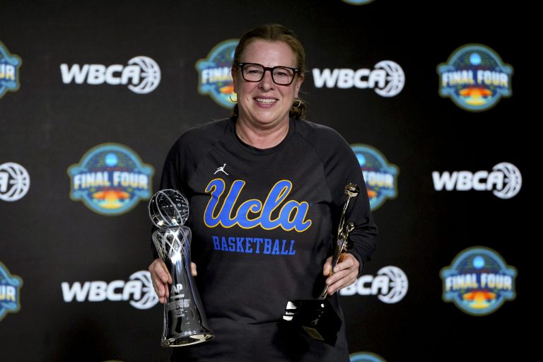UCLA Bruins coach Cori Close poses with the AP and WBCA Coach of the Year trophies during press conference at Amalie Arena.