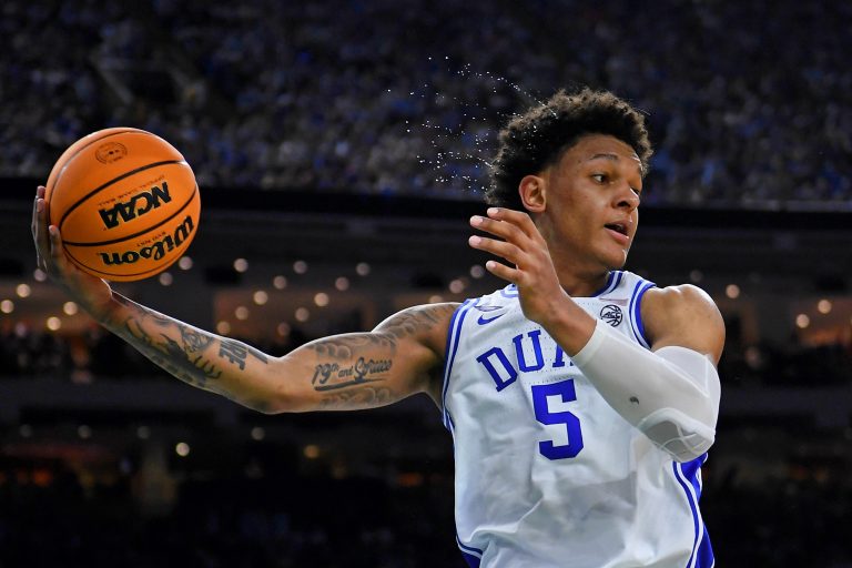 Sweat flies through the air as Duke Blue Devils forward Paolo Banchero (5) saves a ball from going out of bounds against the North Carolina Tar Heels during the second half during the 2022 NCAA men's basketball tournament Final Four semifinals at Caesars Superdome.