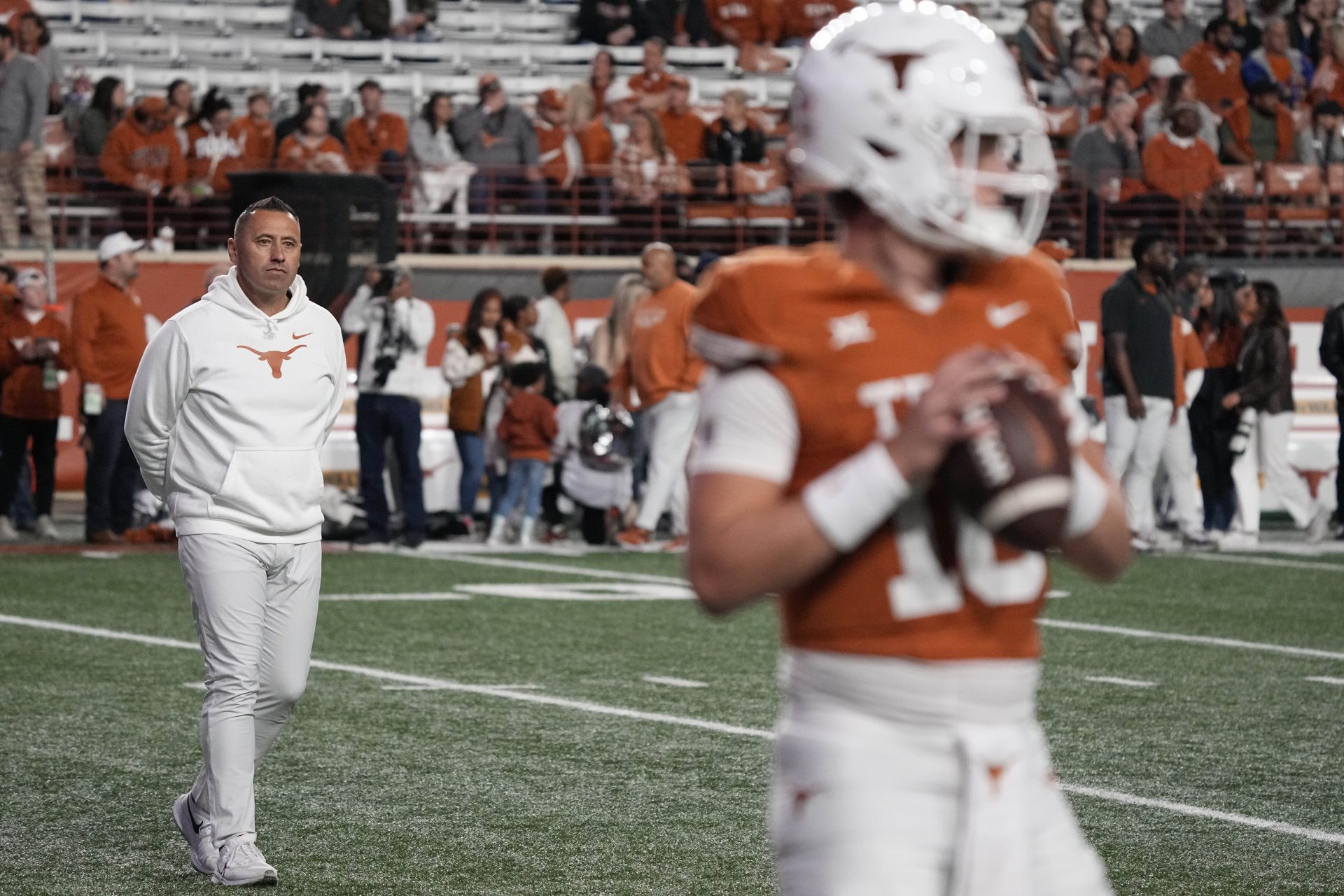 Texas Longhorns head coach Steve Sarkisian observes quarterback Arch Manning (16) warming up before a game against the Texas Tech Red Raiders at Darrell K Royal-Texas Memorial Stadium.