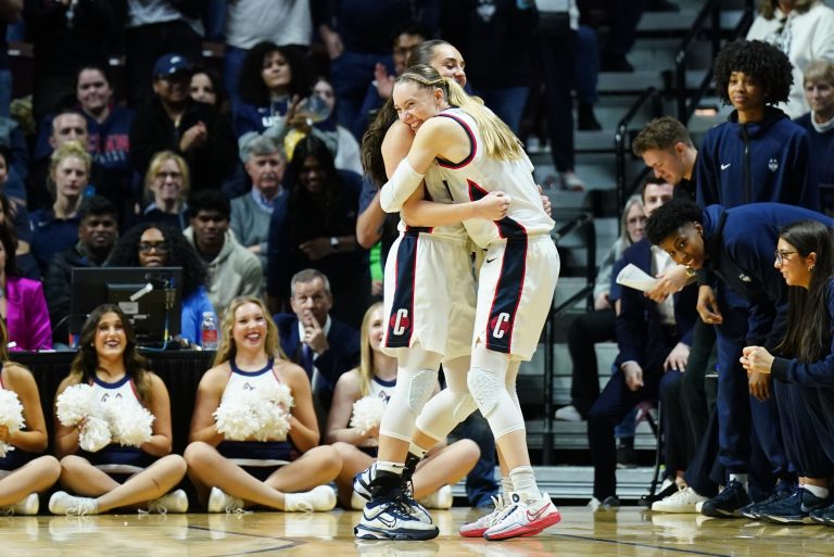 UConn Huskies guard Paige Bueckers (5) hugs guard Nika Muhl (10) late in the fourth quarter as they take on the Georgetown Hoyas at Mohegan Sun Arena.