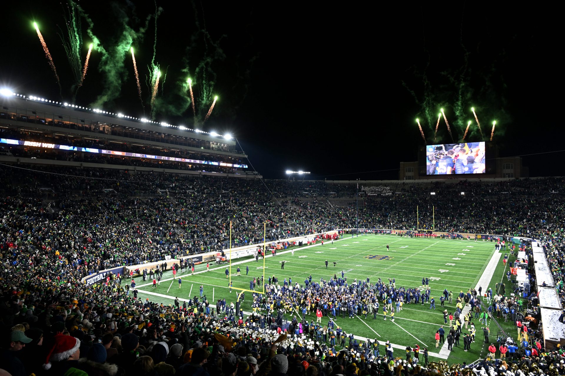 Notre Dame Fighting Irish players and coaches celebrate after the Irish defeated the Indiana Hoosiers in the first round of the College Football Playoff at Notre Dame Stadium.