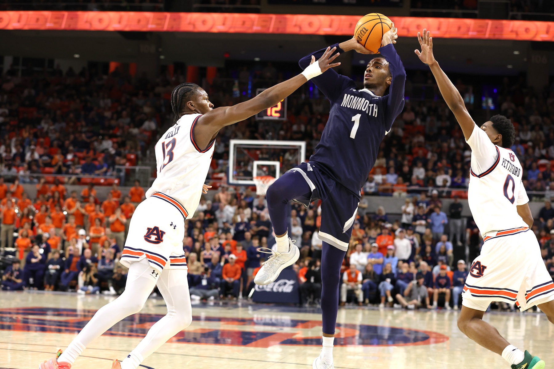Monmouth Hawks guard Abdi Bashir Jr. (1) goes for a shot between Auburn Tigers guards Miles Kelly (13) and Tahaad Pettiford (0) during the first half at Neville Arena.