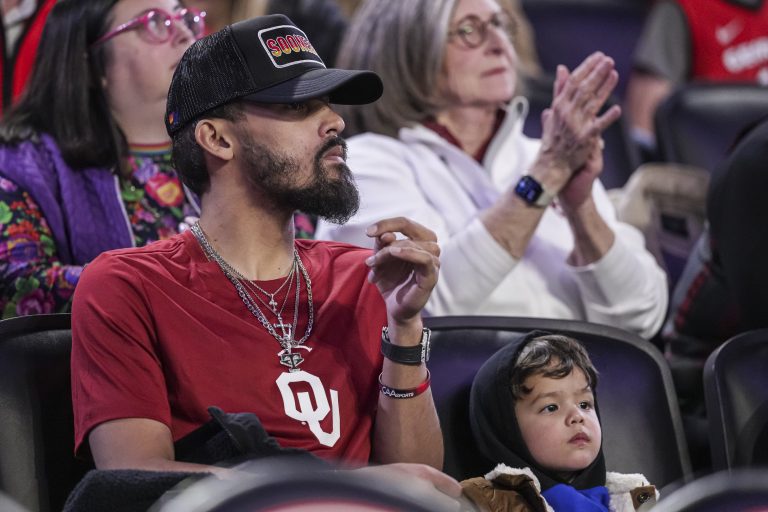 Atlanta Hawks player Trae Young with his son Tydus watch the game between the Georgia Bulldogs and the Oklahoma Sooners at Stegeman Coliseum
