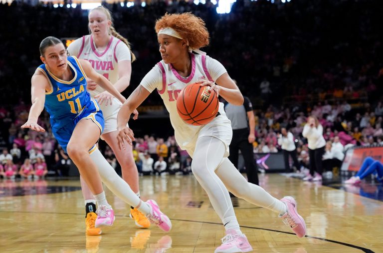 Iowa guard Aaliyah Guyton (11) drives toward the basket as UCLA guard Gabriela Jaquez (11) defends Sunday, Feb. 23, 2025 at Carver-Hawkeye Arena in Iowa City, Iowa.