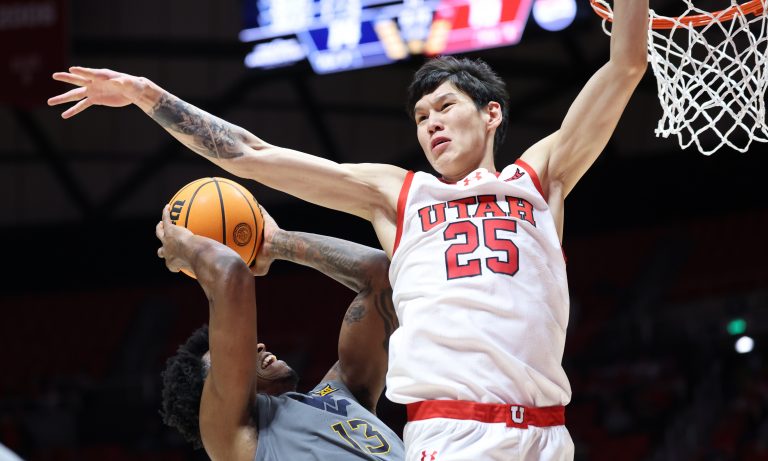 West Virginia Mountaineers forward Amani Hansberry (13) goes to the basket as Utah Utes guard Mike Sharavjamts (25) defends during the first half at Jon M. Huntsman Center.