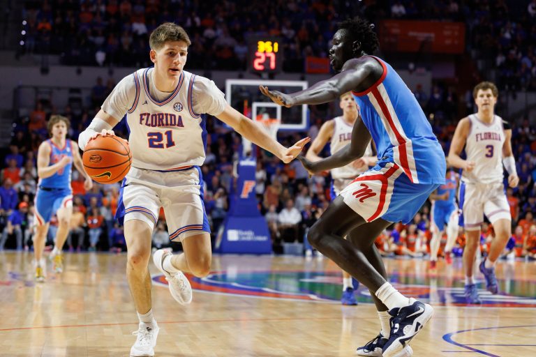 Florida Gators forward Alex Condon (21) drives to the basket while Mississippi Rebels forward John Bol (10) defends during the second half at Exactech Arena at the Stephen C. O'Connell Center.