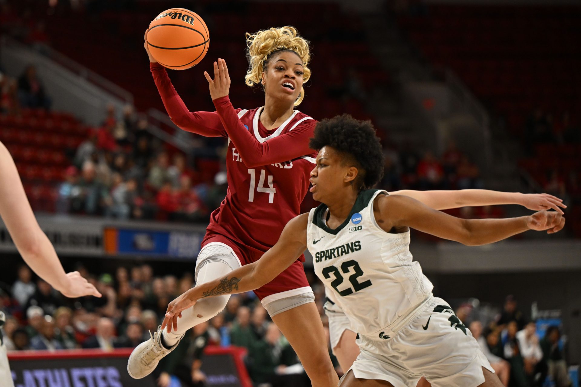 Harvard Crimson guard Harmoni Turner (14) goes up for a pass against Michigan State Spartans guard Nyla Hampton (22) during the second half at James T. Valvano Arena at William Neal Reynolds.
