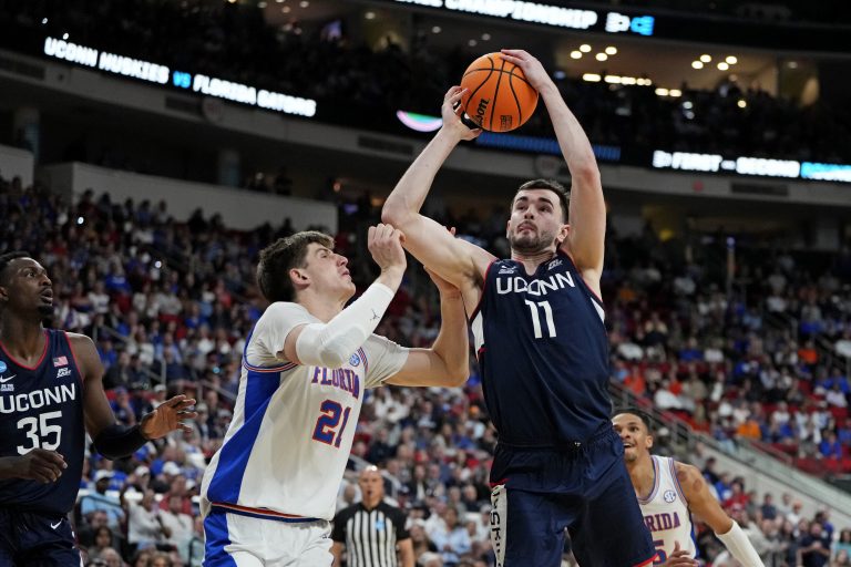Connecticut Huskies forward Alex Karaban (11) drives to the basket as Florida Gators forward Alex Condon (21) defends during the first half in the second round of the NCAA Tournament at Lenovo Center.