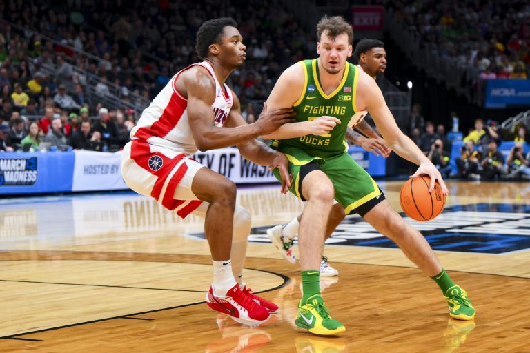 Oregon Ducks center Nate Bittle (32) dribbles the ball against Arizona Wildcats forward Tobe Awaka (30) in the first half at Climate Pledge Arena.