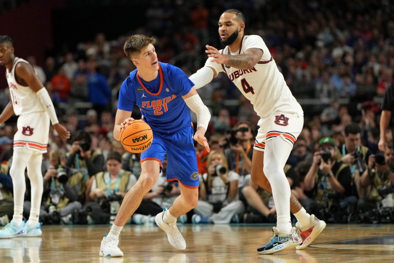 Florida Gators forward Alex Condon (21) controls the ball against Auburn Tigers forward Johni Broome (4) during the first half in the semifinals of the men's Final Four of the 2025 NCAA Tournament at the Alamodome.