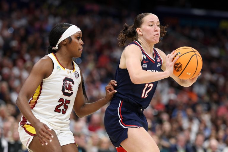 Connecticut Huskies guard Ashlynn Shade (12) passes the ball away from South Carolina Gamecocks guard Raven Johnson (25) during the first halfof the national championship of the women's 2025 NCAA tournament at Amalie Arena.