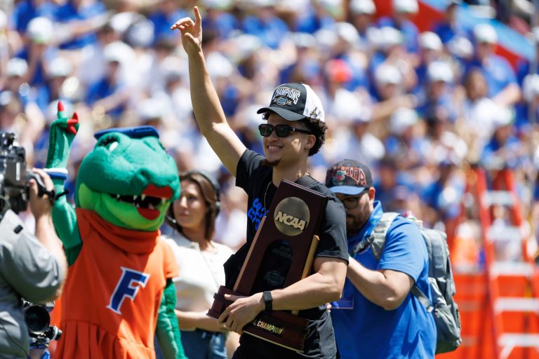 Florida Gators guard Walter Clayton Jr. (1) holds the National Championship trophy walking onto the field during the National Championship celebration at Ben Hill Griffin Stadium.
