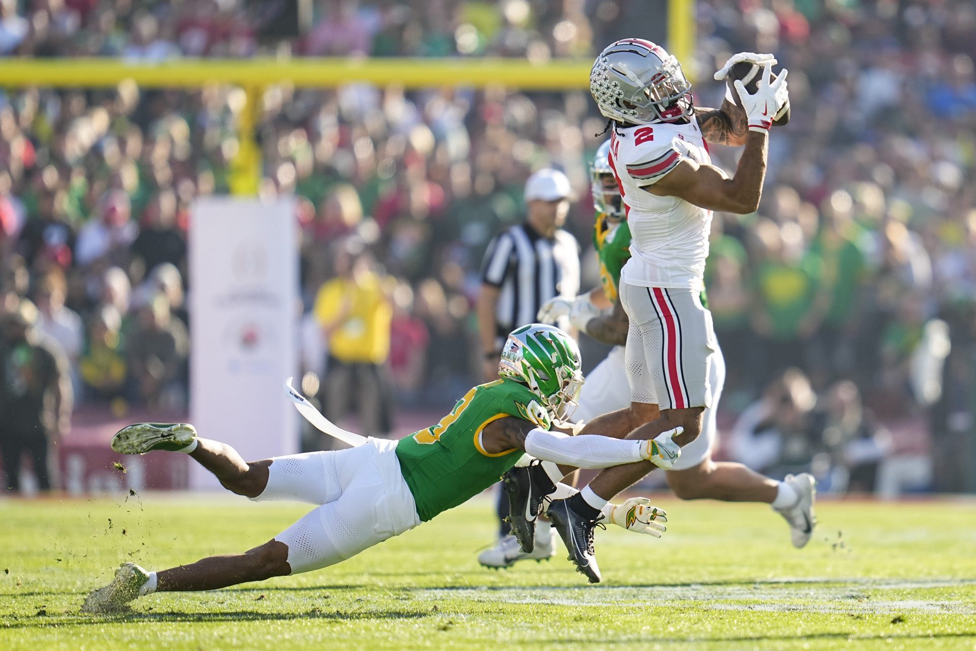 Ohio State Buckeyes wide receiver Emeka Egbuka (2) catches a pass over Oregon Ducks defensive back Nikko Reed (9) during the first half of the College Football Playoff quarterfinal at the Rose Bowl in Pasadena, Calif. on Jan. 1, 2025.