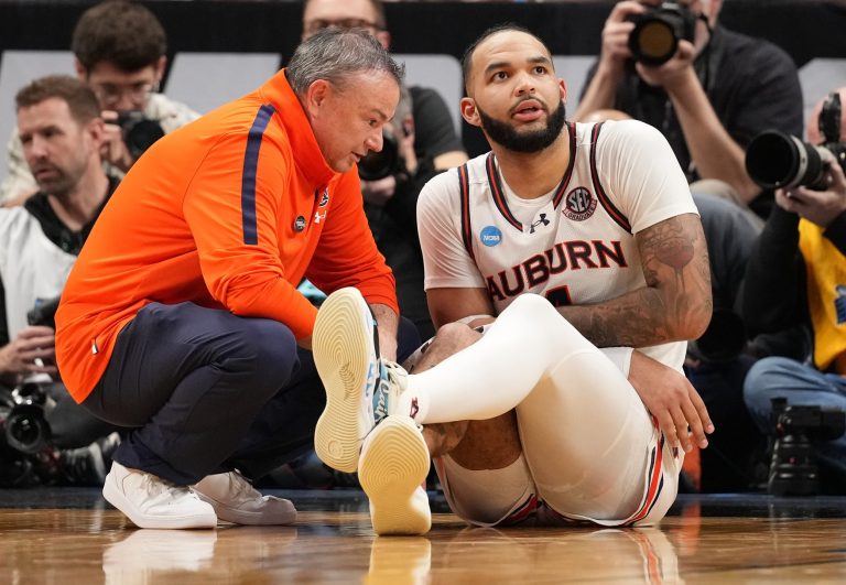 Auburn Tigers forward Johni Broome (4) is looked at by a trainer during the second half in the South Regional final of the 2025 NCAA tournament against the Michigan State Spartans at State Farm Arena.