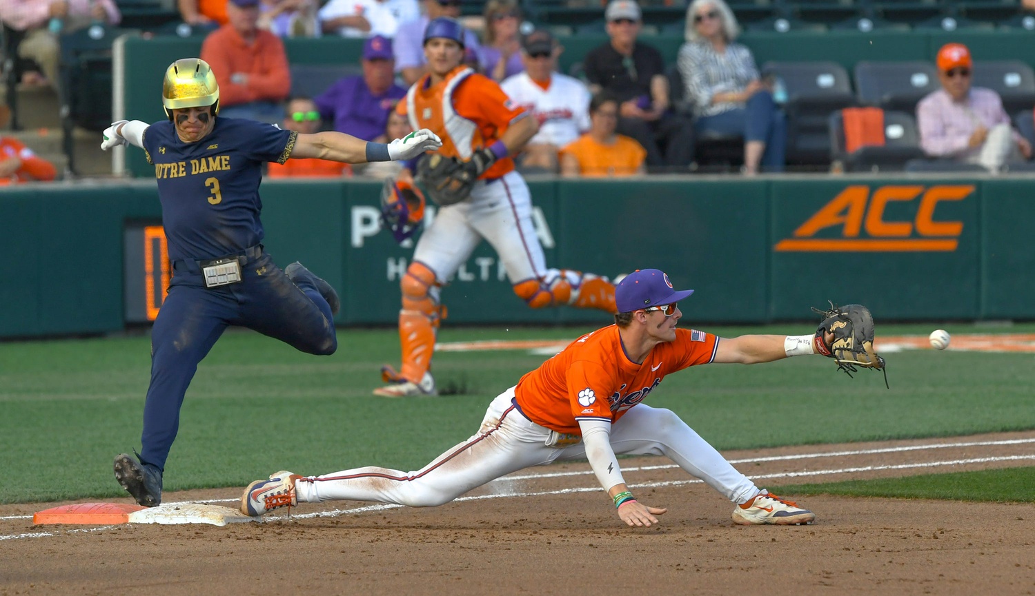 Clemson infielder Luke Gaffney (16) reaches for a ball while Notre Dame junior Estevan Moreno (3) races to first base, during the bottom of the sixth inning at Doug Kingsmore Stadum in Clemson, S.C. Friday, March 14, 2025. Umpires had a video review and determined the runner was out.