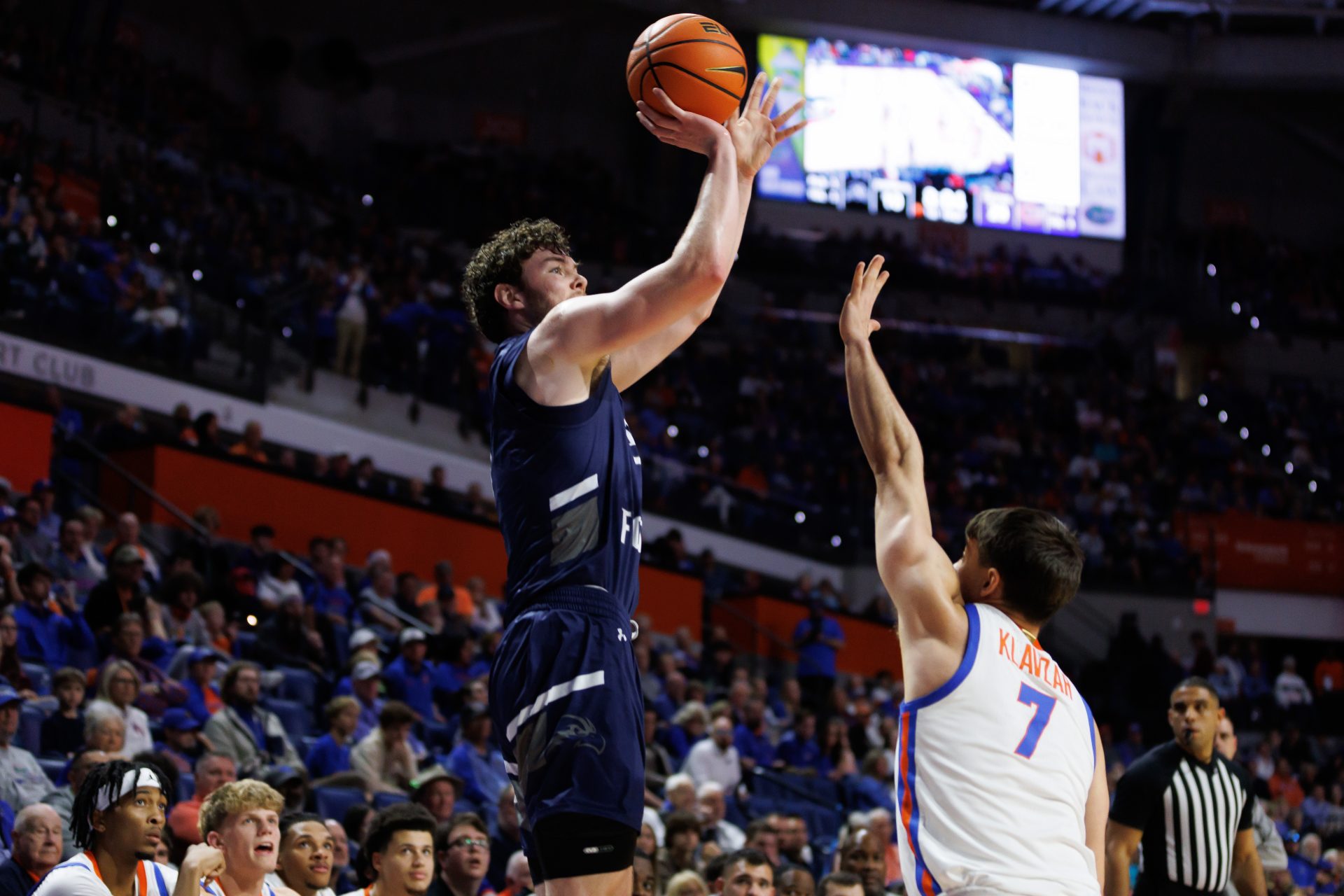 North Florida Ospreys forward Liam Murphy (7) shoots over Florida Gators guard Urban Klavzar (7) during the first half at Exactech Arena at the Stephen C. O'Connell Center.