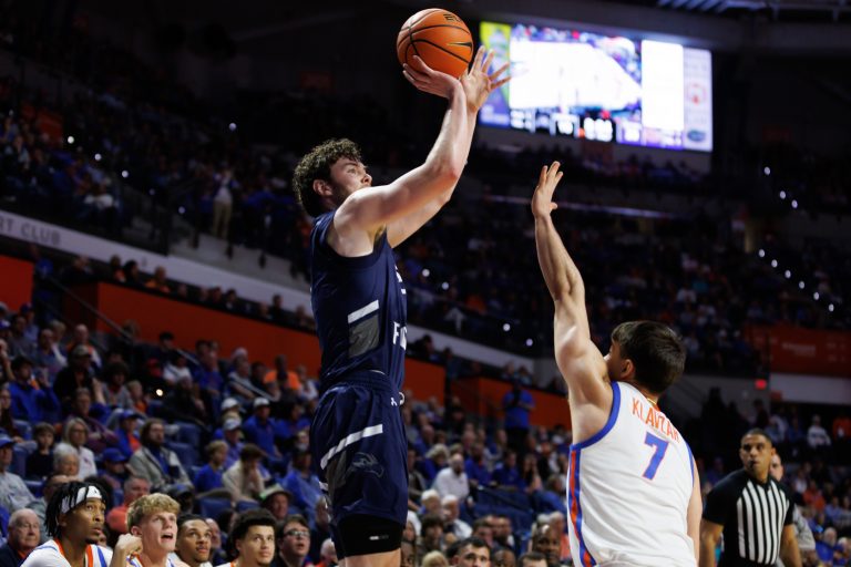 North Florida Ospreys forward Liam Murphy (7) shoots over Florida Gators guard Urban Klavzar (7) during the first half at Exactech Arena at the Stephen C. O'Connell Center.