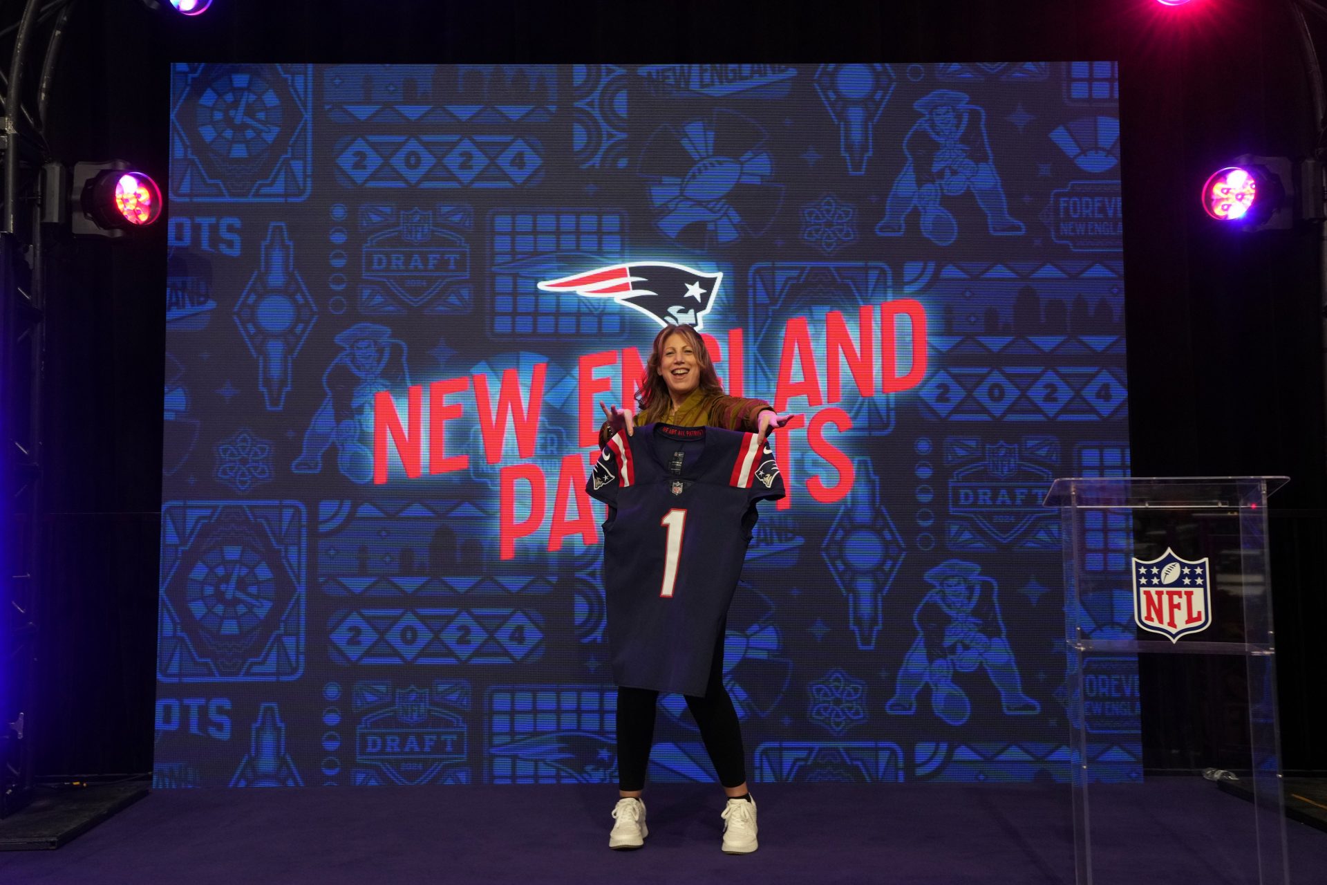 A New England Patriots female fan poses at the NFL Draft exhibit at the NFL Experience at the Mandalay Bay South Convention Center.