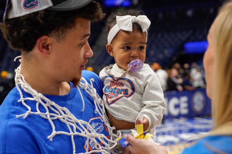 Florida guard Walter Clayton Jr. (1) holds his daughter Leilani as they celebrate their win over Tennessee after the Southeastern Conference tournament