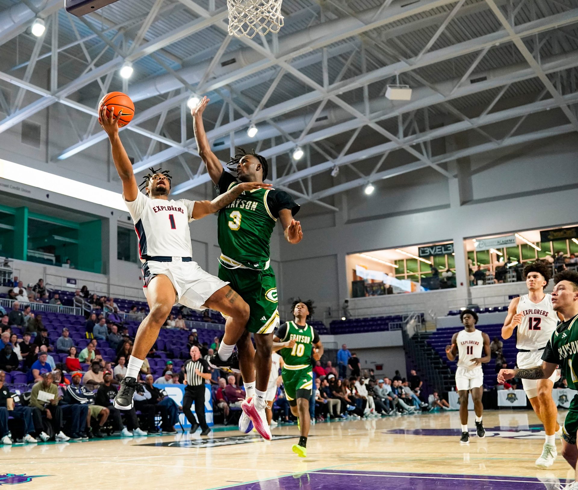 Columbus Explorers guard Cello Jackson (1) makes a lay up on a breakaway as Grayson Rams guard Caleb Holt (3) tries to defend during the third quarter of a City of Palms Classic quarterfinal game at Suncoast Credit Union Arena in Fort Myers, Fla., on Friday, Dec. 20, 2024.