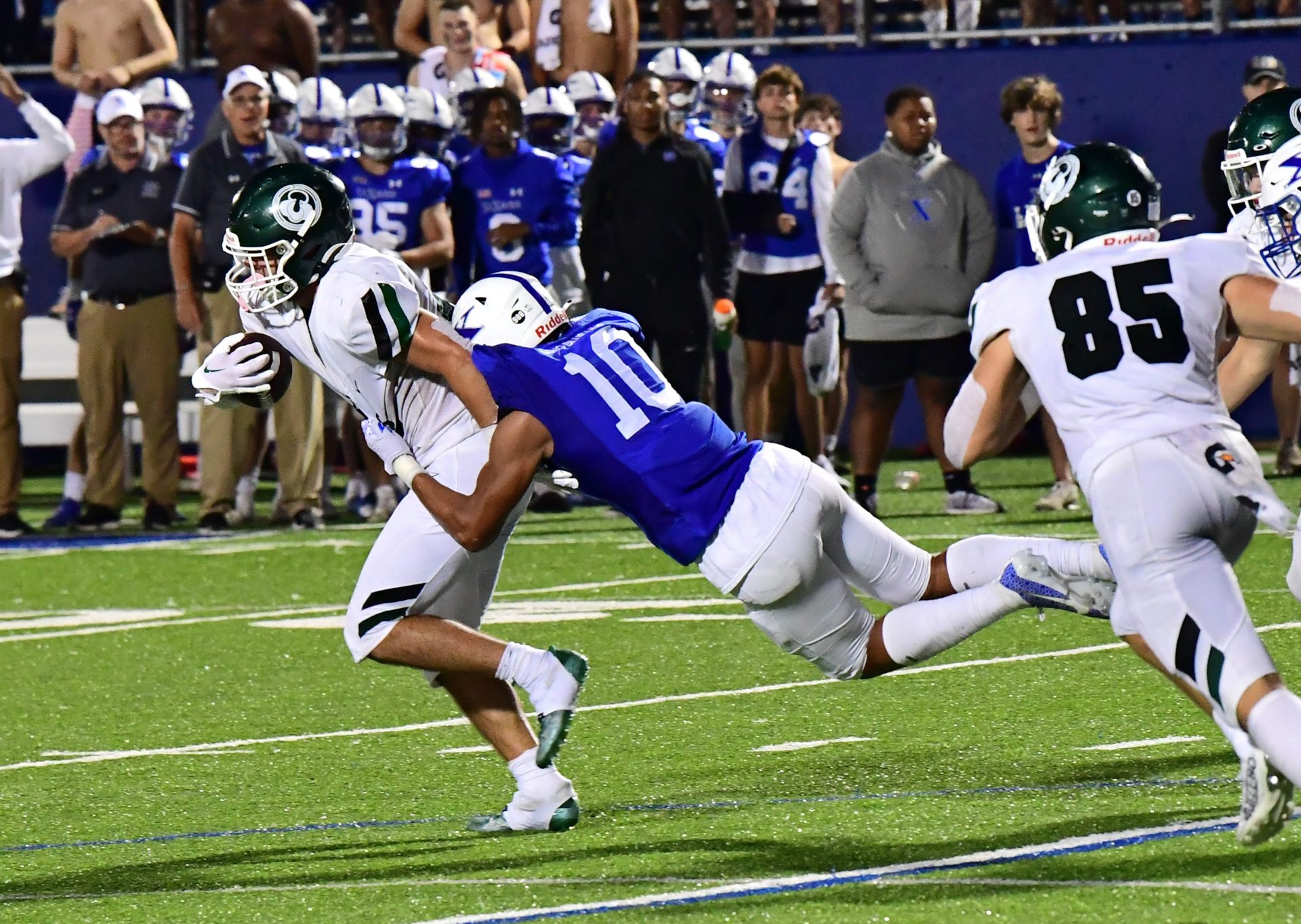 Jeremiah Lynn of Louisville Trinity carries St. Xavier's Jakobe Clapper (10) with him as he gains a first down for the Shamrocks at RDI Stadium,