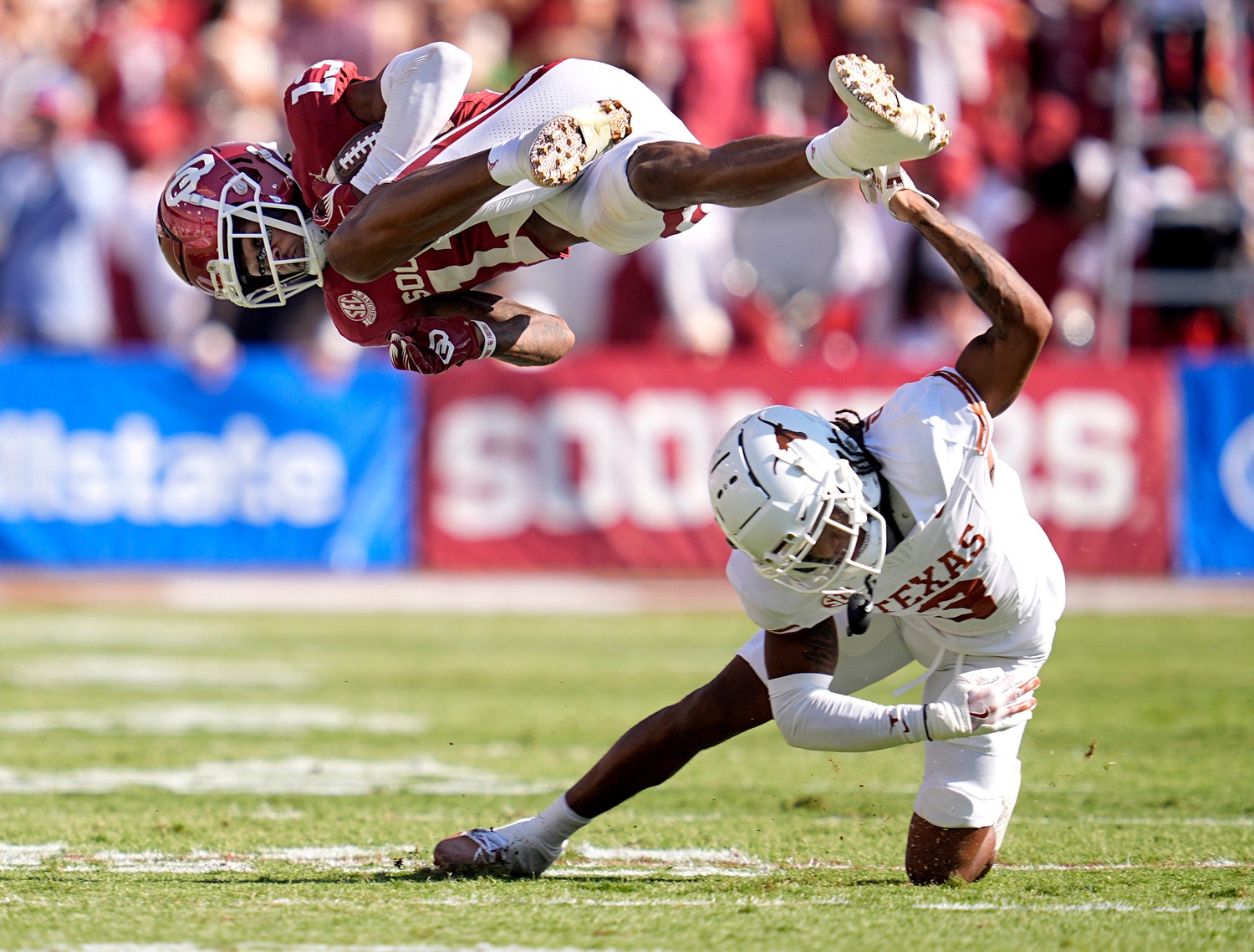 Oklahoma Sooners wide receiver J.J. Hester (13) is up ended by defesive back Jaylon Guilbeau (3) in the first half of the Red River Rivalry college football game between the University of Oklahoma Sooners and the Texas Longhorn at the Cotton Bowl Stadium in Dallas, Texas, Saturday, Oct., 12, 2024.