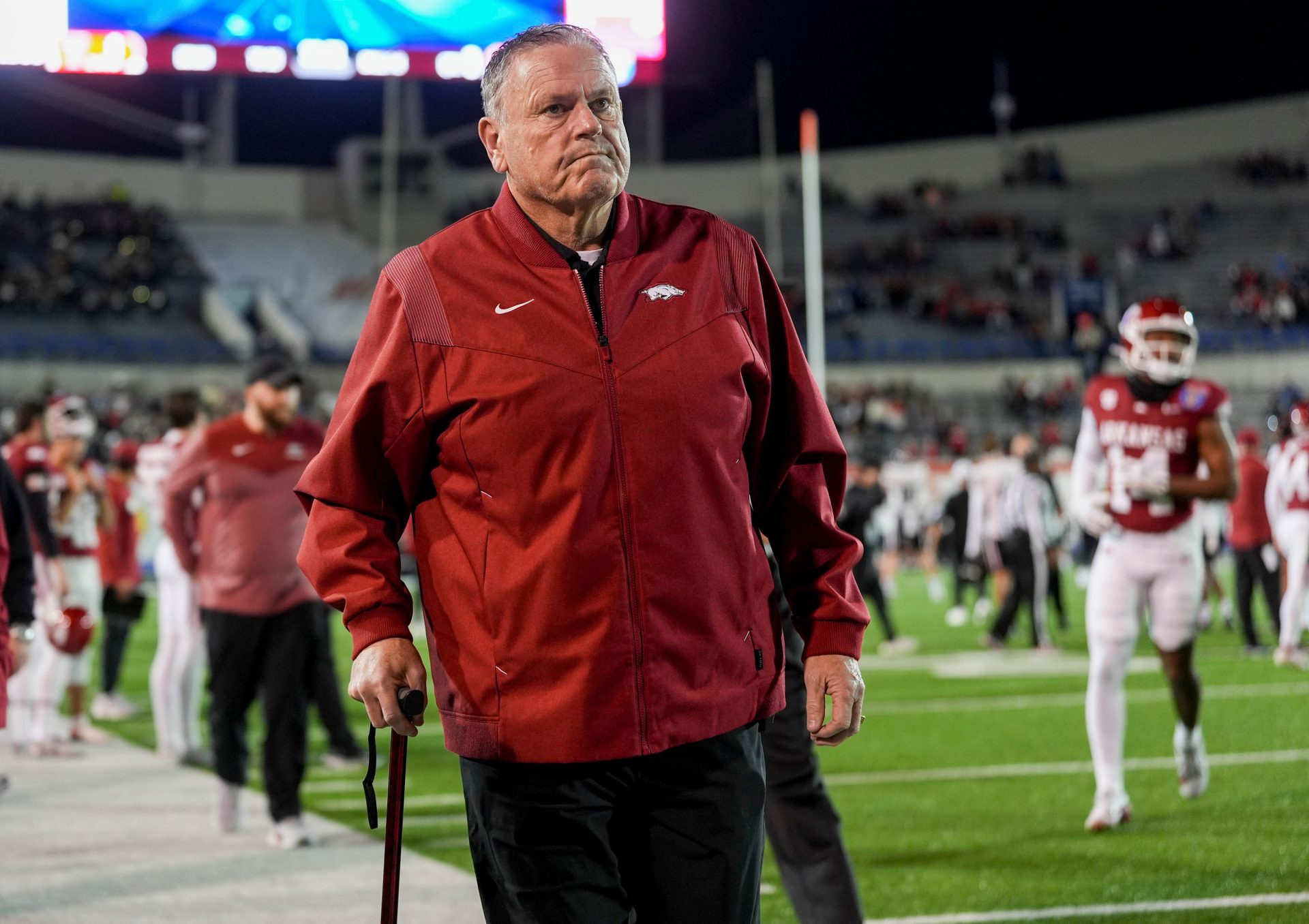 Arkansas' head coach Sam Pittman walks down the sideline assisted by a cane as both teams warm up before the AutoZone Liberty Bowl kicks off between Arkansas and Texas Tech in Memphis, Tenn., on Friday, December 27, 2024.