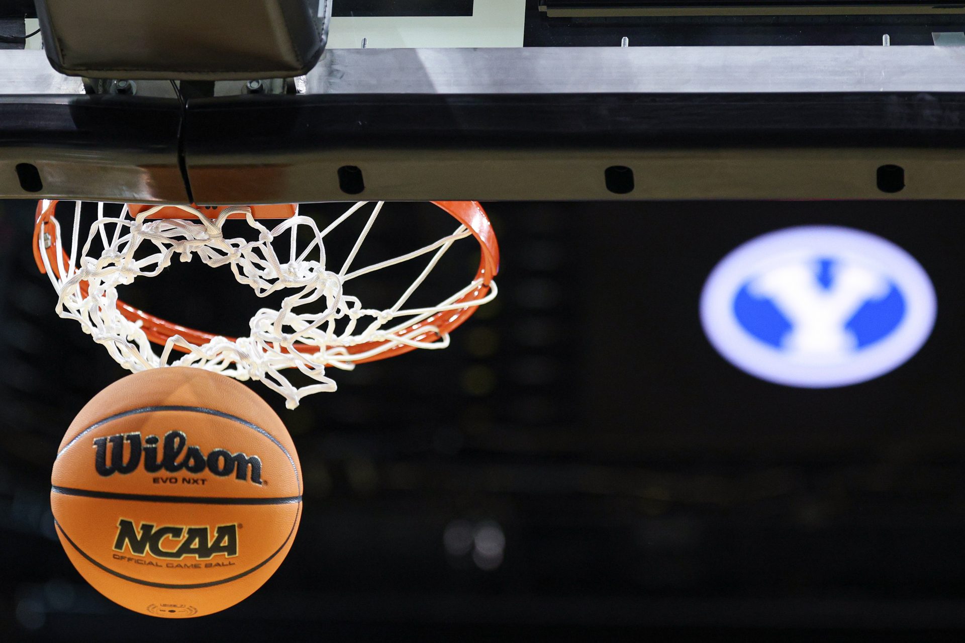 An NCAA Wilson official game ball passes thorough a basket in front of an Brigham Young Cougars logo during a practice sessions in preparation for an East Regional semifinal games at Prudential Center.