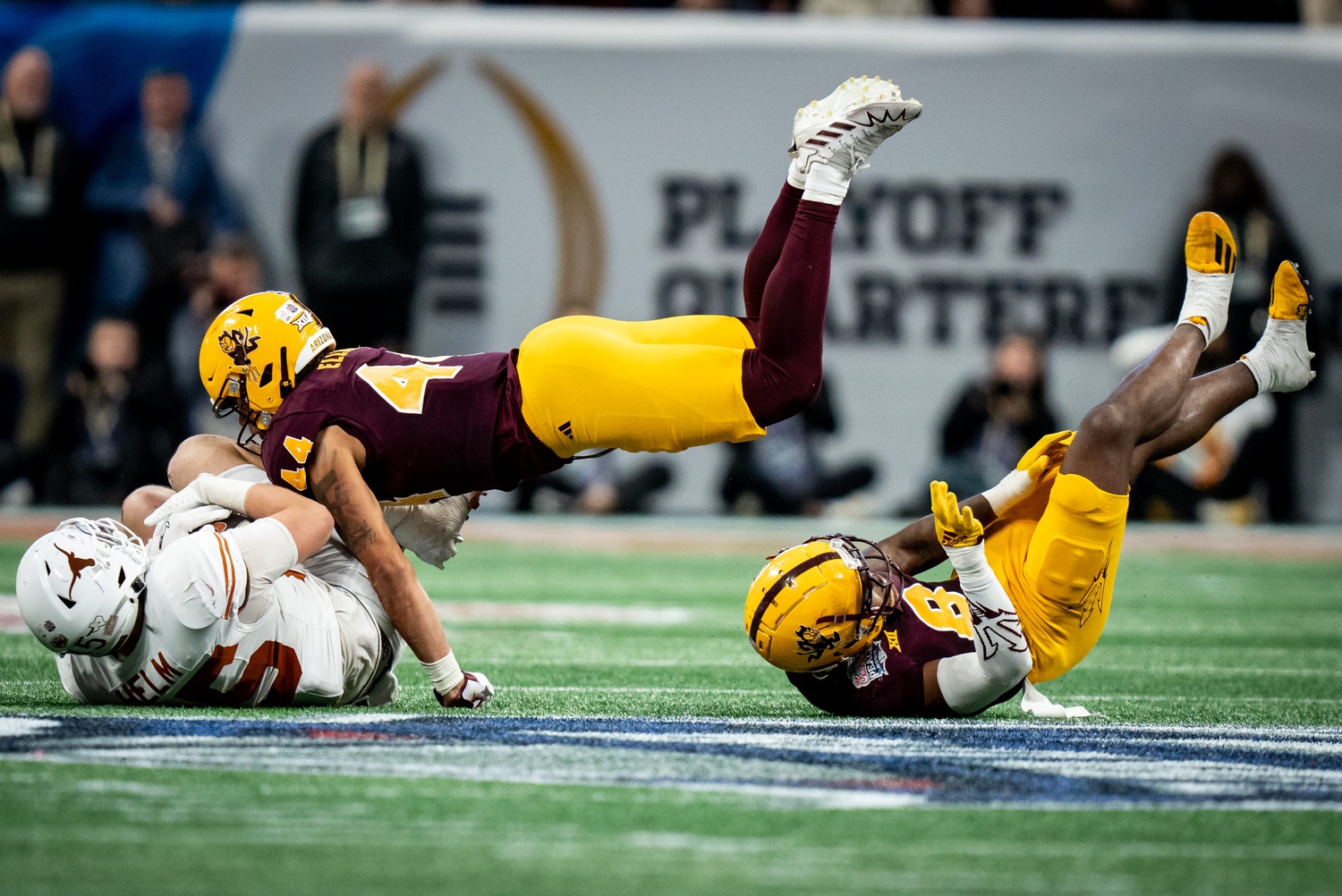 Arizona State Sun Devils linebackers Keyshaun Elliott (44) andinebacker Jordan Crook (8) tumble to the ground as Texas Longhorns tight end Gunnar Helm (85) catches the ball the fourth quarter as the Texas Longhorns play the Arizona State Sun Devils in the Peach Bowl College Football Playoff quarterfinal at Mercedes-Benz Stadium in Atlanta, Georgia, Jan. 1, 2025.