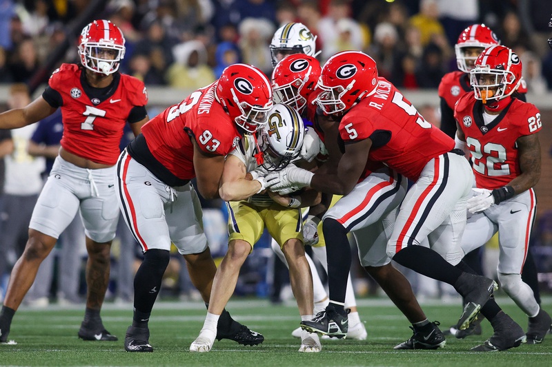 Georgia Bulldogs defensive lineman Tyrion Ingram-Dawkins (93) and linebacker C.J. Allen (33) and linebacker Raylen Wilson (5) tackle Georgia Tech Yellow Jackets quarterback Haynes King (10) in the second half at Bobby Dodd Stadium at Hyundai Field.