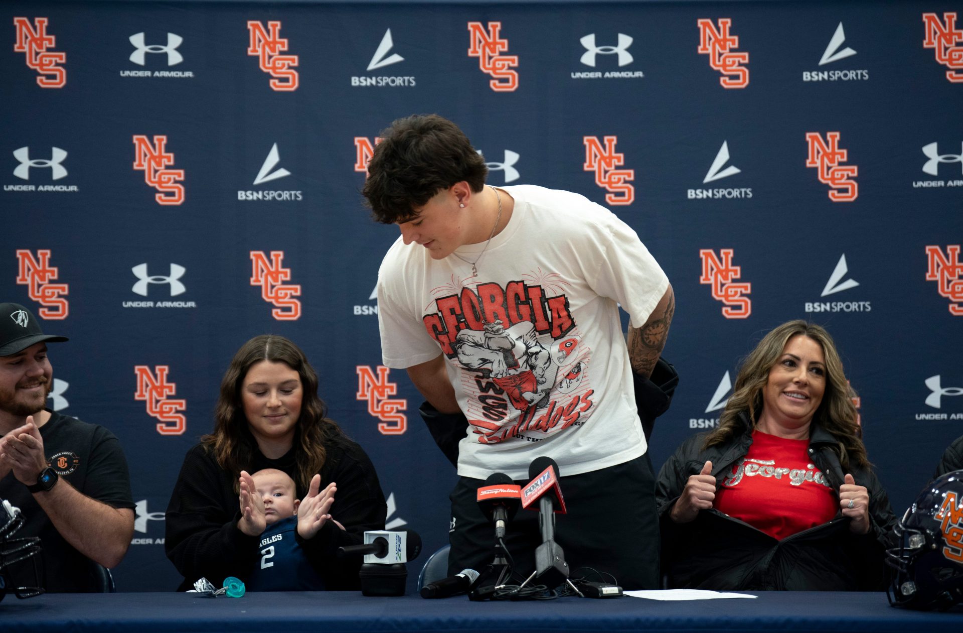 Nashville Christian's five-star quarterback Jared Curtis unveils his new t-shirt and his decision to sign with Georgia with his family at his side at Nashville Christian School in Nashville, Tenn., Monday, May 5, 2025. They are, from left, Blaine Allsbrooks, Kaitlyn Allsbrooks, sister, Hudson, 2, nephew, Barbara and Jesse Curtis, parents.