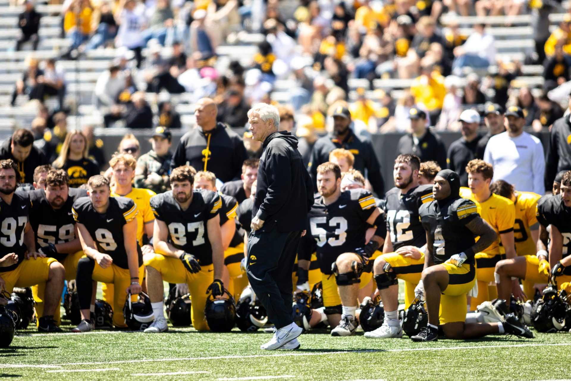Iowa head coach Kirk Ferentz talks with players during a spring NCAA football open practice at Kinnick Stadium.