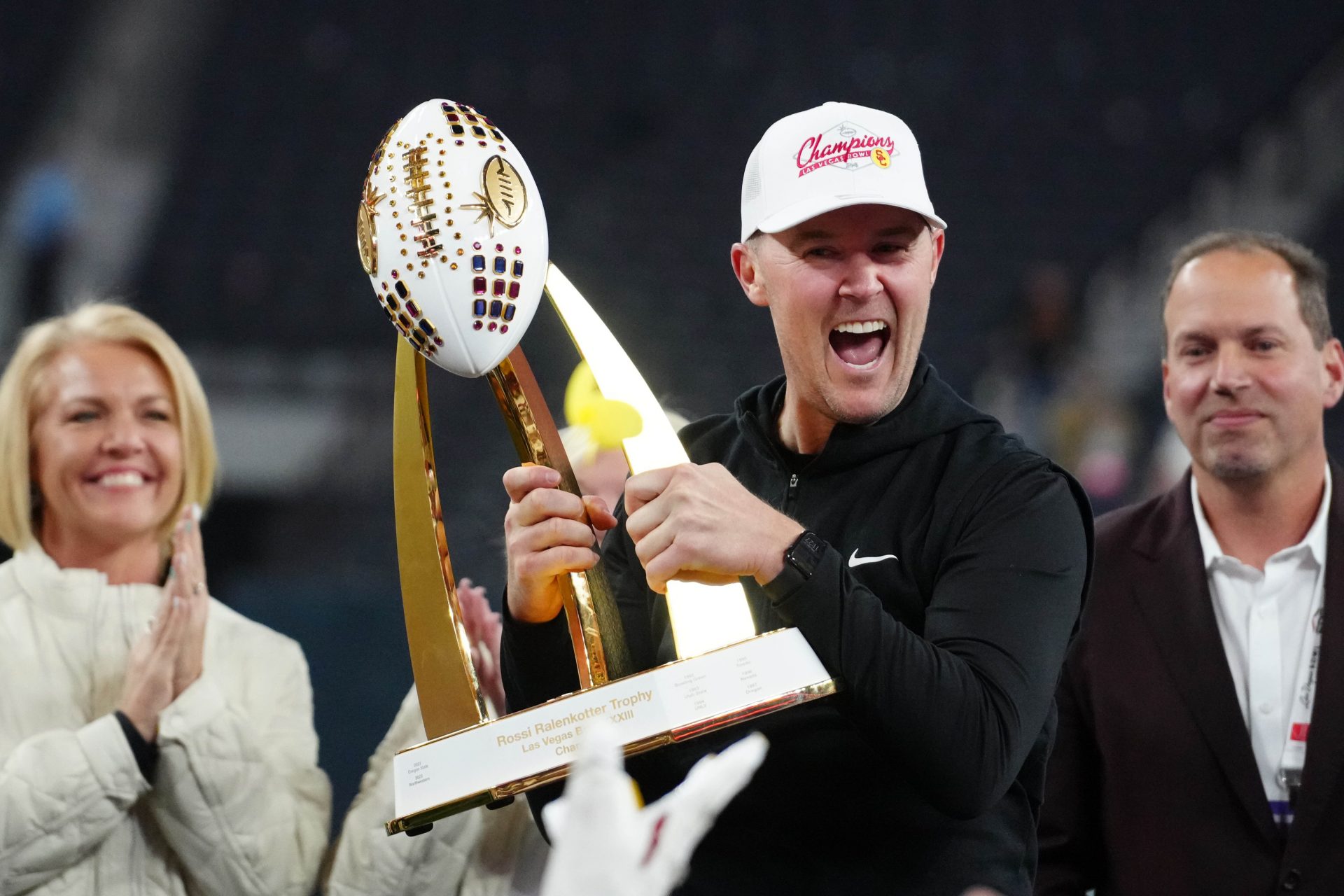 Southern California Trojans head coach Lincoln Riley holds the championship trophy after the game against the Texas A&M Aggies at Allegiant Stadium.