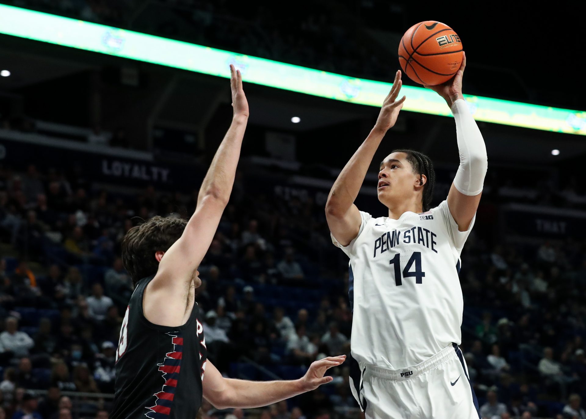 Penn State Nittany Lions forward Yanic Konan Niederhauser (14) drives the ball to the basket as Penn Quakers forward/center Nick Spinoso (13) defends during the first half at Bryce Jordan Center.