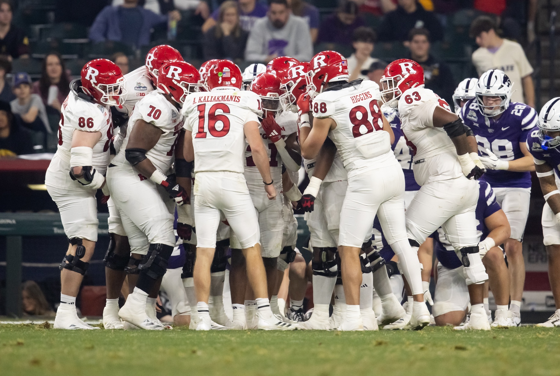 Rutgers Scarlet Knights quarterback Athan Kaliakmanis (16) and tight end Mike Higgins (88) in the huddle with teammates against the Kansas State Wildcats during the Rate Bowl at Chase Field.