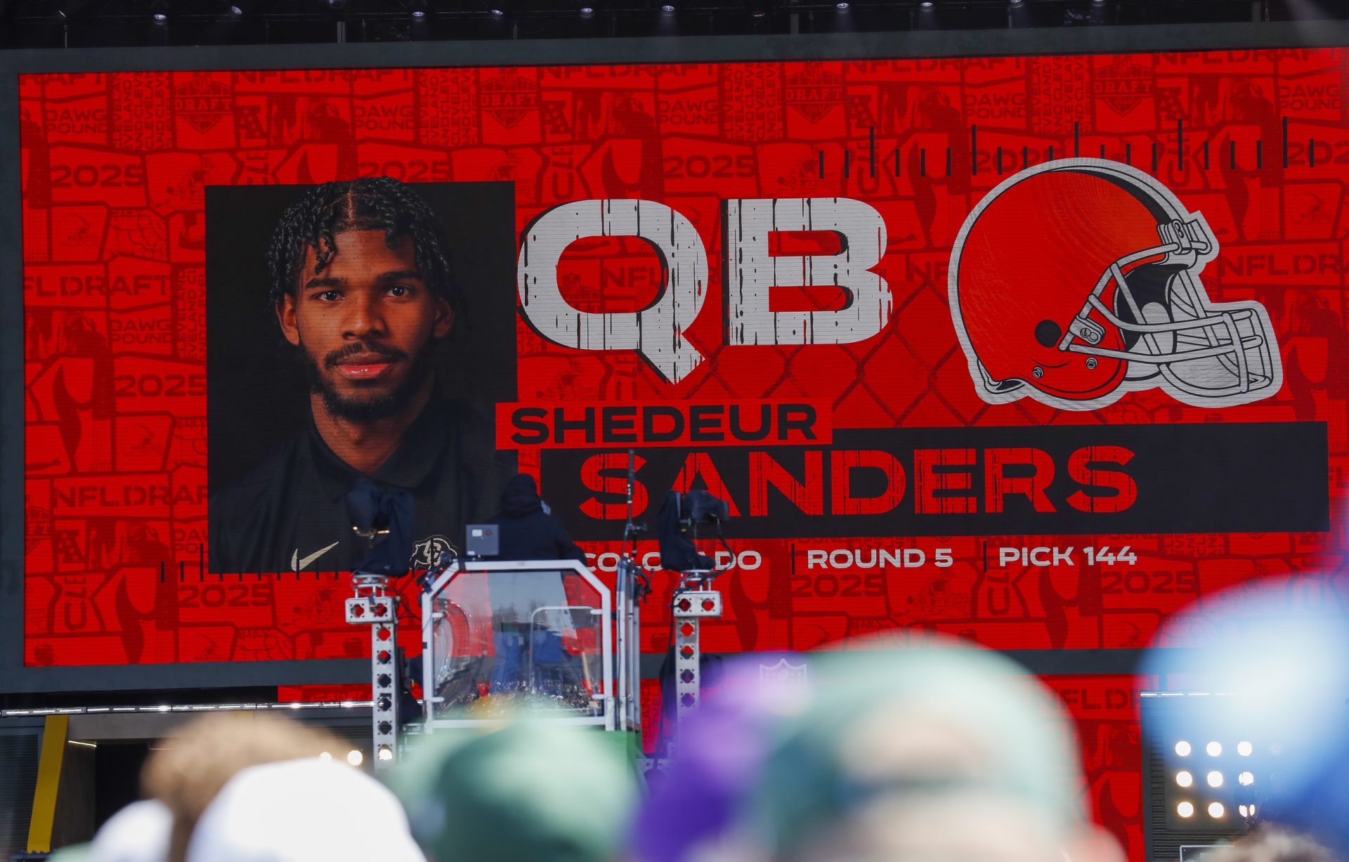 A graphic announcing Colorado quarterback Shedeur Sanders’ selection by the Cleveland Browns with the 144th overall pick is seen in the Draft Theater during the third day of the 2025 NFL Draft at Lambeau Field.