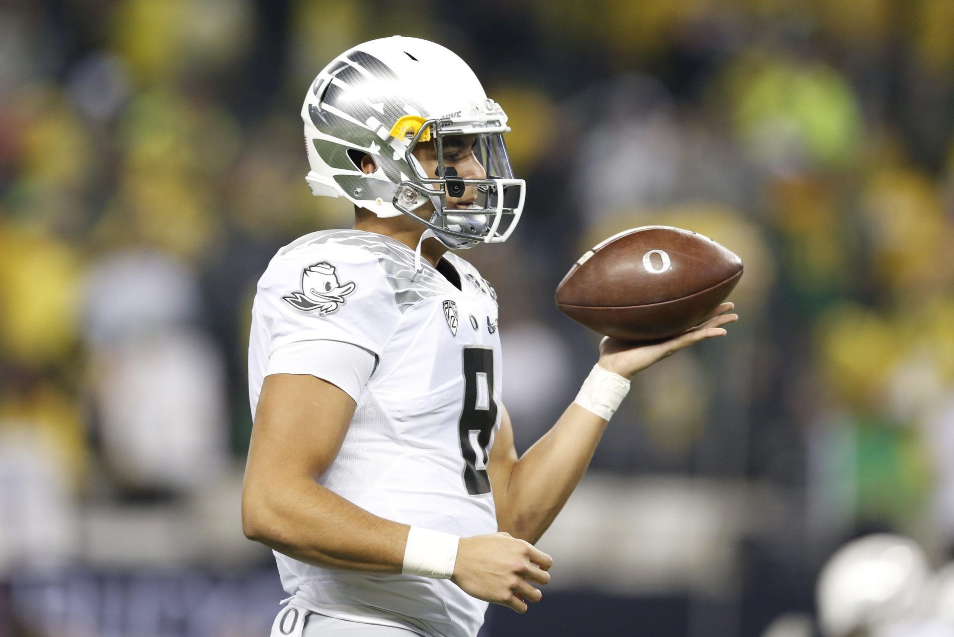 Oregon Ducks quarterback Marcus Mariota (8) twirls a football before the 2015 CFP National Championship Game against the Ohio State Buckeyes at AT&T Stadium.