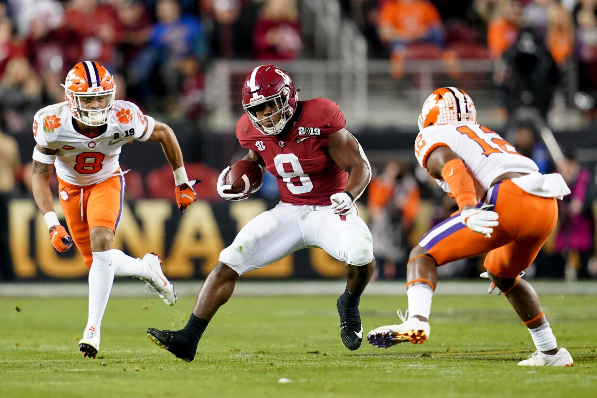 Alabama Crimson Tide running back Josh Jacobs (8) runs the ball as Clemson Tigers cornerback A.J. Terrell (8) and defensive back K'Von Wallace (12) defend during the second quarter in the 2019 College Football Playoff Championship game at Levi's Stadium.