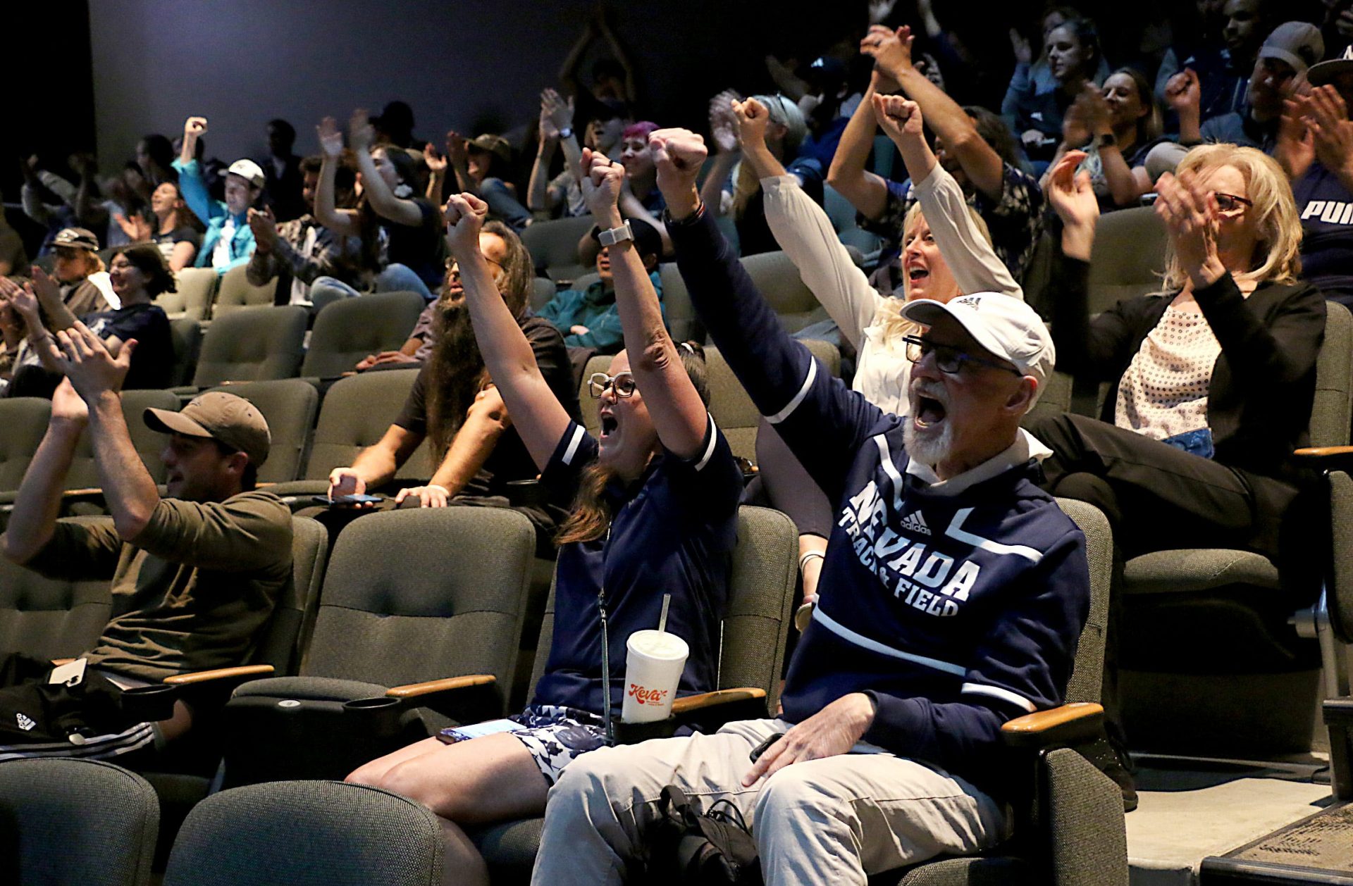 Kirk and Bean Elias, front right, react with others who gathered to watch the Nevada men’s basketball team in the NCAA tournament during a watch party in the theater at Joe Crowley Student Union in Reno on March 21, 2024. The Wolf Pack fell to Dayton during the game.