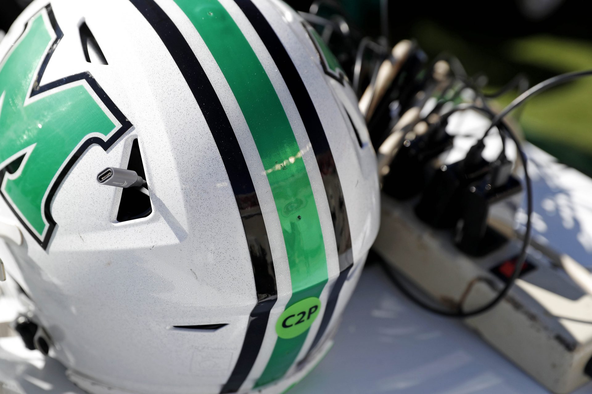 Helmets for the Marshall Thundering Herd rest on a charging table before the game against the Virginia Tech Hokies at Lane Stadium.