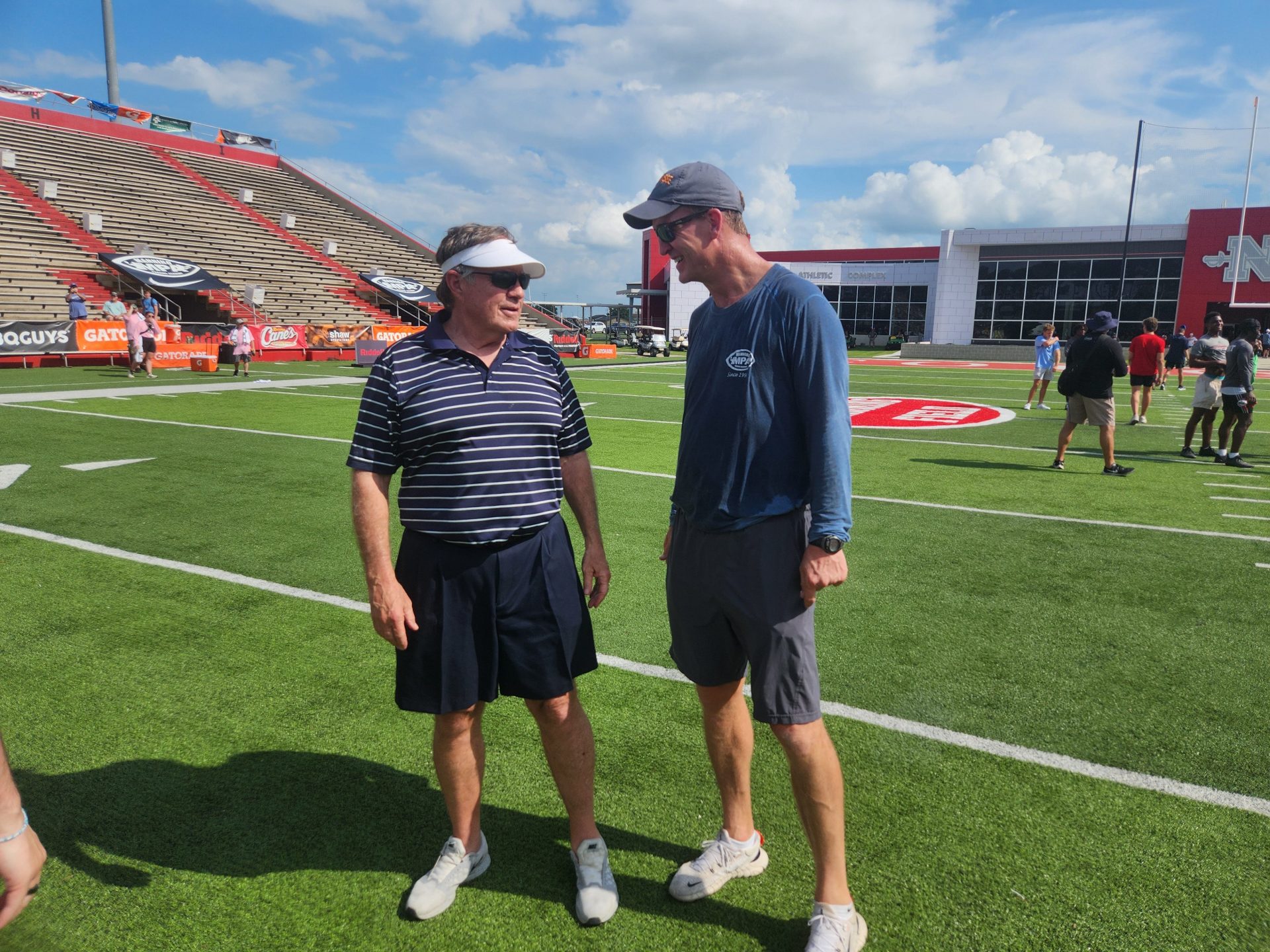 Bill Belichick, left, talks with Peyton Manning, right, at the 2024 Manning Passing Academy.