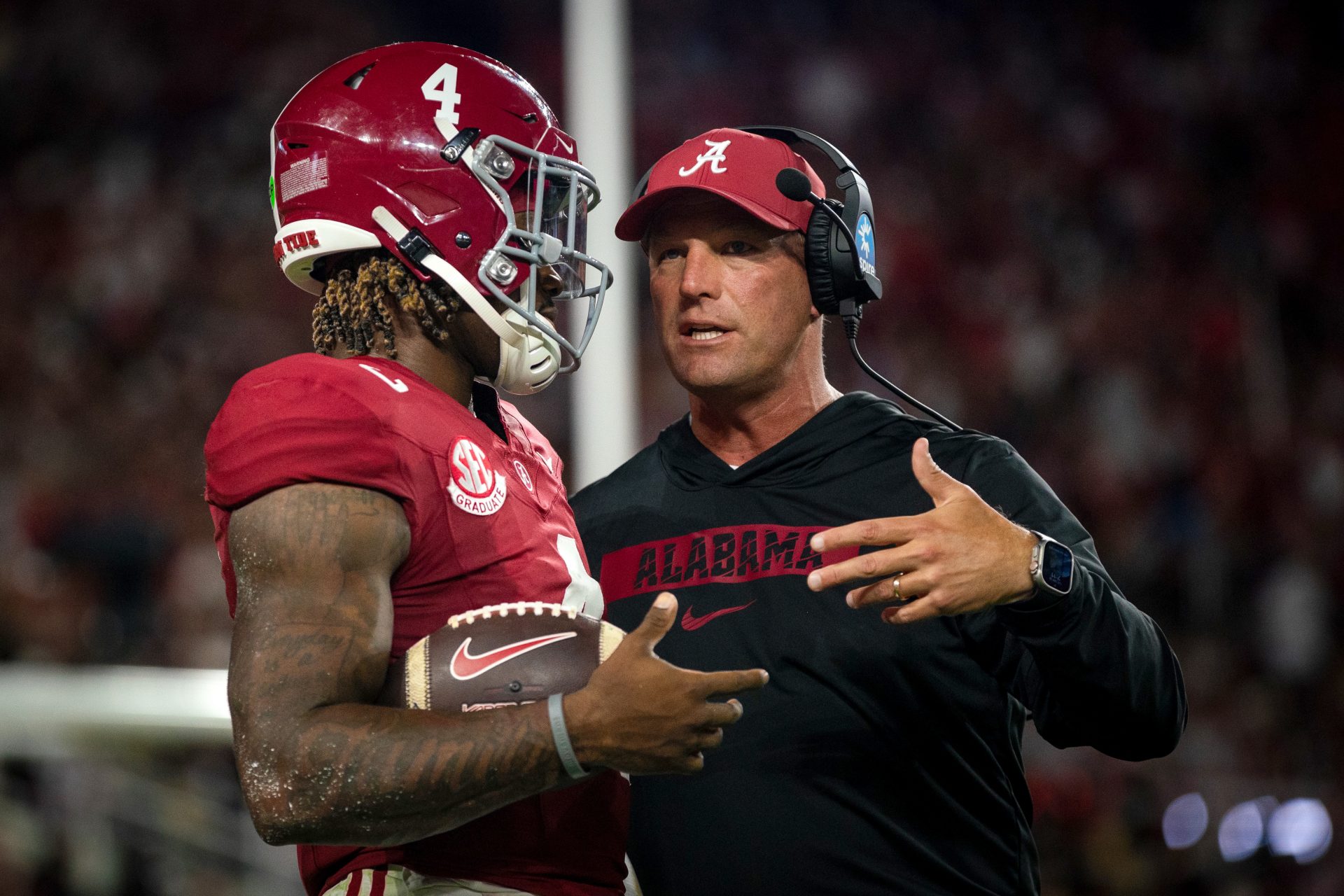 Alabama Crimson Tide quarterback Jalen Milroe (4) and head coach Kalen DeBoer talk during a timeout in the first quarter against the Georgia Bulldogs at Bryant-Denny Stadium.