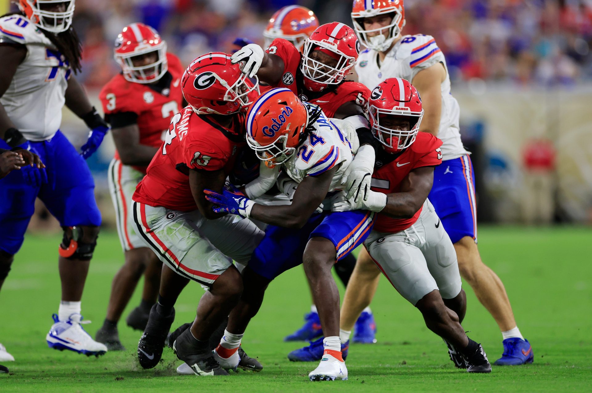 Florida running back Ja'Kobi Jackson (24) is stopped by Georgia defensive linemen Mykel Williams (13) and Christen Miller (52) and linebacker Raylen Wilson (5) on Nov. 2, 2024 at EverBank Stadium in Jacksonville, Fla. Georgia won 34-20.