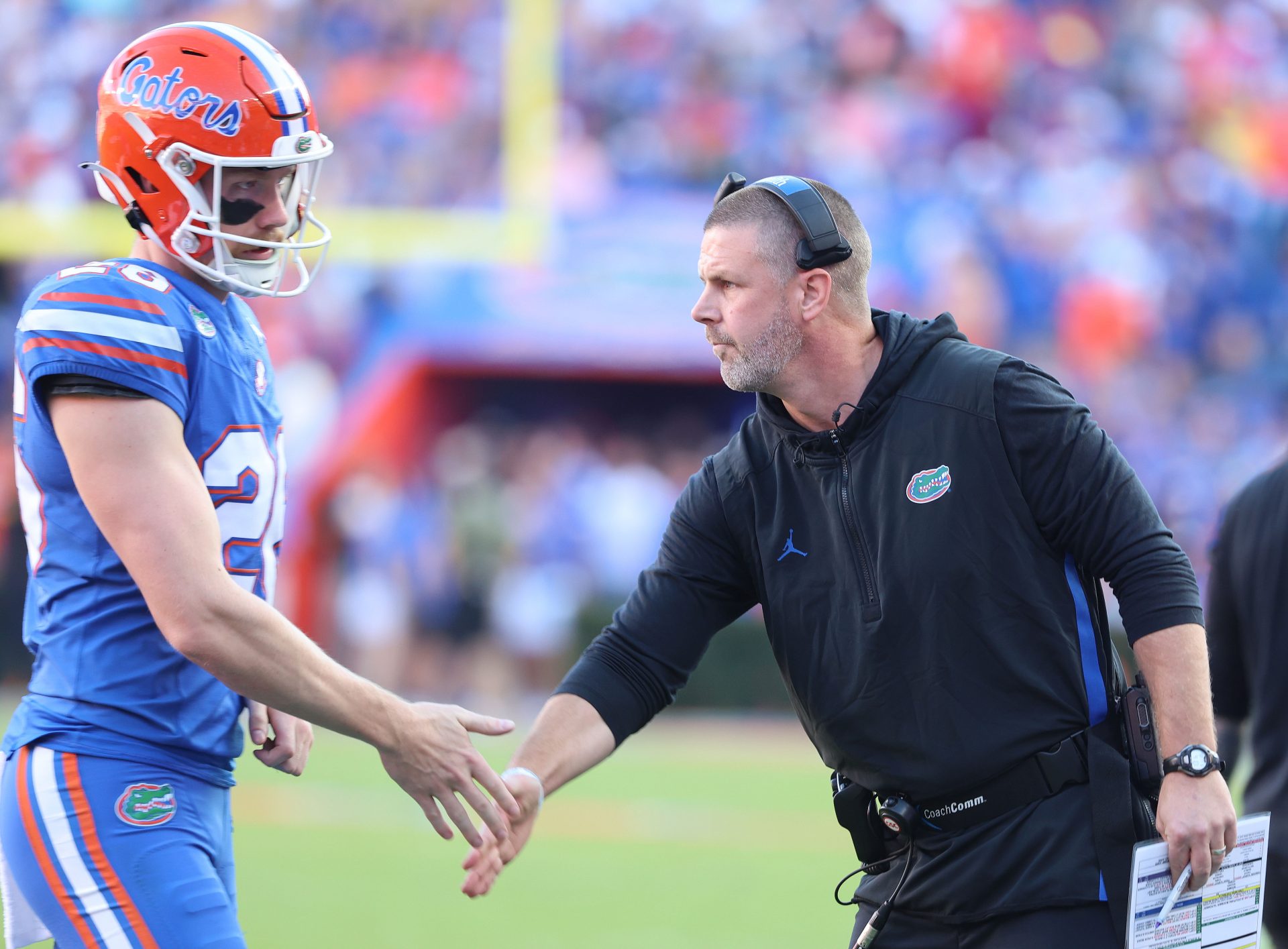 Florida Gators head coach Billy Napier high fives Florida Gators punter Jeremy Crawshaw (26) against the LSU Tigers   during the first half at Ben Hill Griffin Stadium.