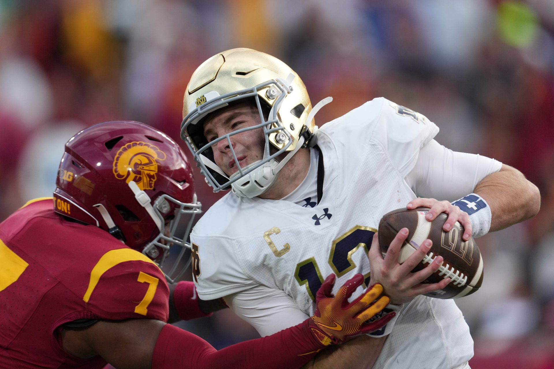 Notre Dame Fighting Irish quarterback Riley Leonard (13) is pressured by Southern California Trojans safety Kamari Ramsey (7) in the second half at United Airlines Field at Los Angeles Memorial Coliseum.