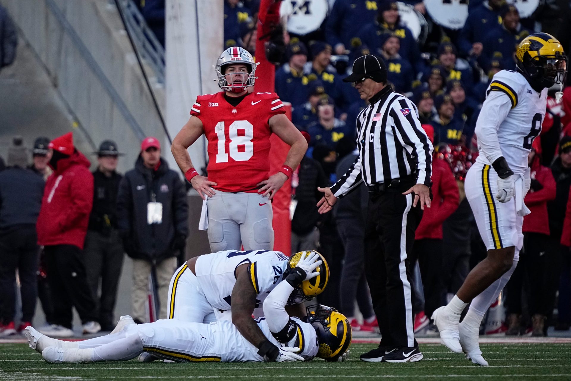 Ohio State Buckeyes quarterback Will Howard (18) reacts as Michigan Wolverines players celebrate a fourth down stop to seal the game during the second half of the NCAA football game at Ohio Stadium in Columbus on Saturday, Nov. 30, 2024. Michigan won 13-10.