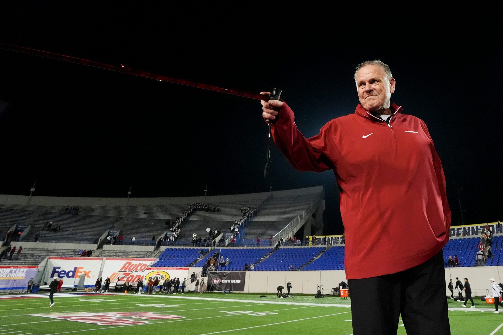 Arkansas' head coach Sam Pittman points to his players and Arkansas fans with his cane after Arkansas defeated Texas Tech 36-26 in the AutoZone Liberty Bowl in Memphis, Tenn., on Friday, December 27, 2024.